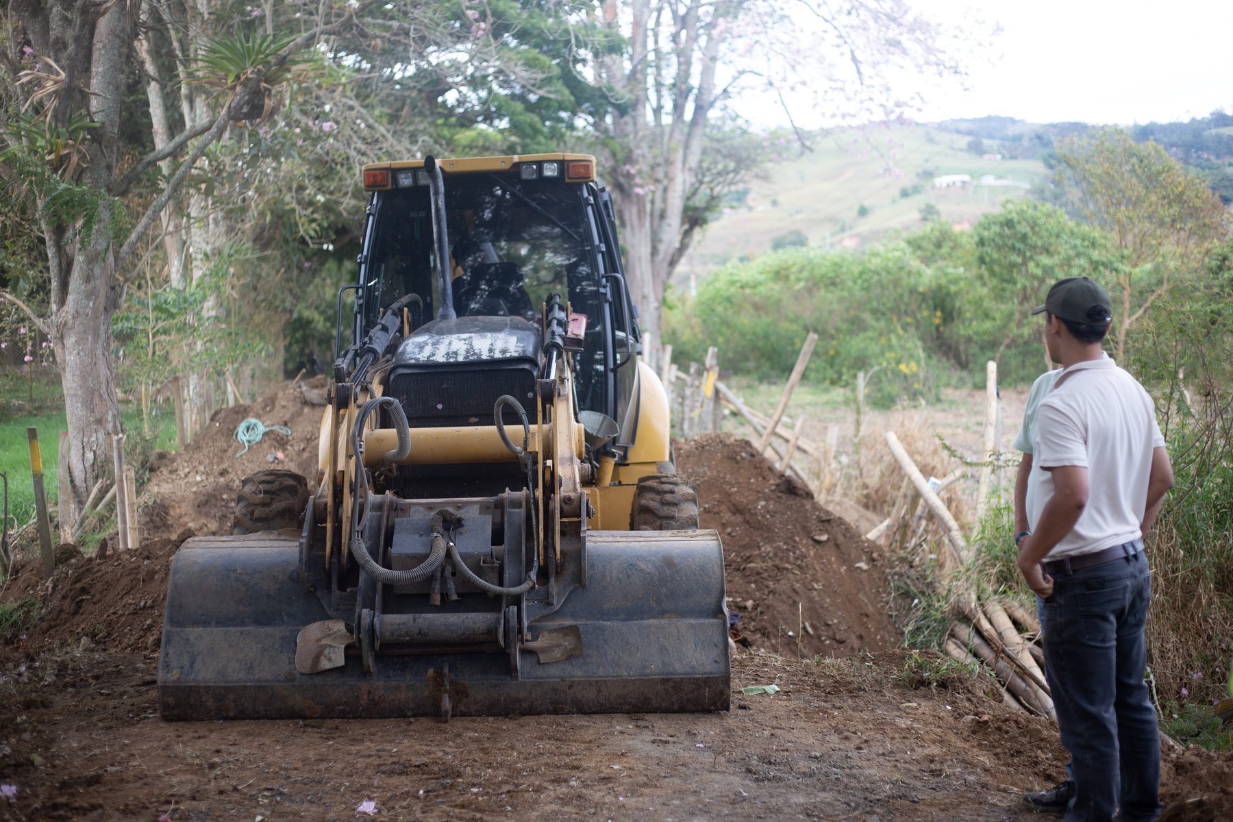 A backhoe clearing a track in the hills to reach a deployment site